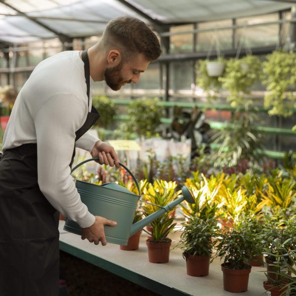 medium-shot-man-watering-plants-min